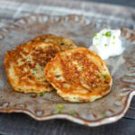 a plate of potato pancakes with sour cream