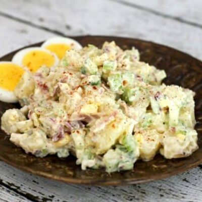 buttermilk potato salad on a plate with extra sliced hard boiled eggs.