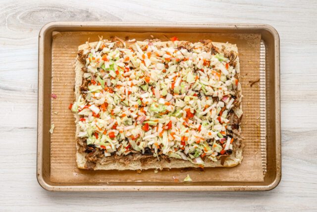 The pork is topped with BBQ sauce and slaw.
