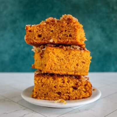 pumpkin cake with broiled coconut pecan topping, stacked on a plate