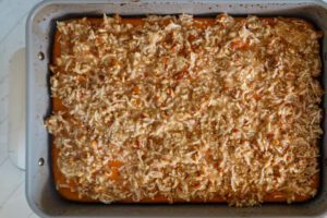 Pumpkin cake with coconut pecan topping, ready to broil.