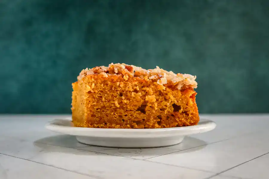 A slice of pumpkin cake with a broiled coconut topping.