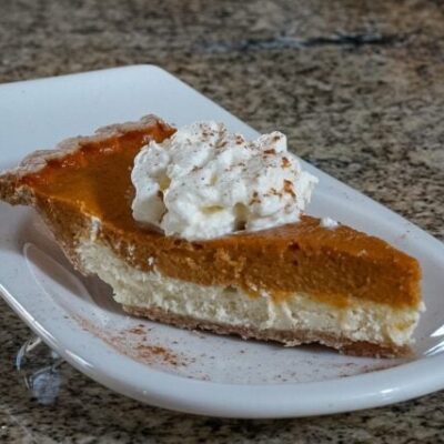 pumpkin pie with cream cheese layer on a dessert plate