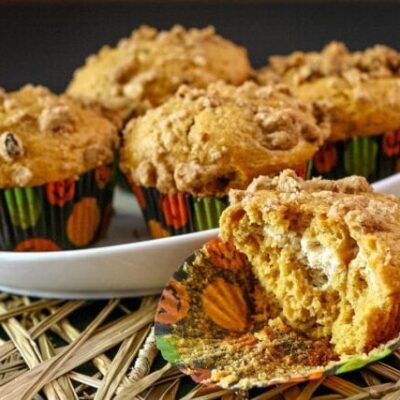 dish with pumpkin cream cheese muffins and one cut in half
