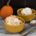pumpkin rice pudding in dessert dishes with whipped cream