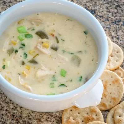 Creamy chicken soup with vegetables and green onions.