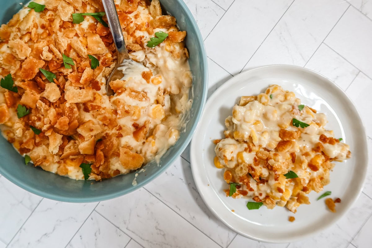 Scalloped corn in a serving dish with a small plate/serving on the side.