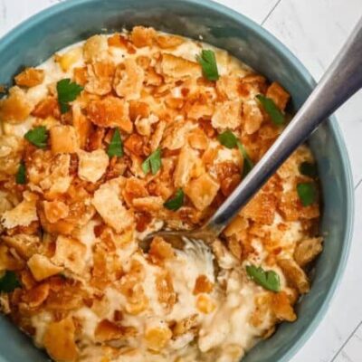 quick skillet scalloped corn in a serving bowl with spoon