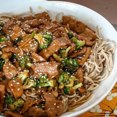sesame noodles in a bowl with a meat stir-fry