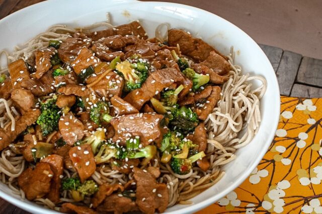 sesame noodles in a bowl with a meat stir-fry