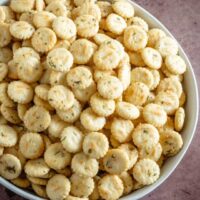 Oyster crackers with ranch dressing and dill in a large serving bowl.