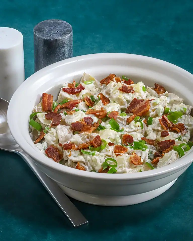 Creamy potato salad with bacon and green onions.