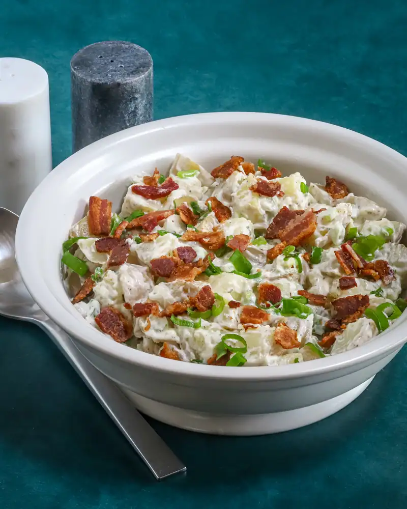 Creamy potato salad with bacon and green onions.