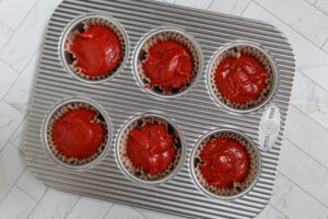 red velvet cupcake batter in the pan.
