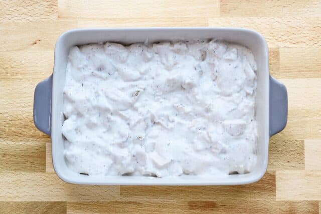 The creamy Ritz chicken casserole filling is in the prepared baking dish.