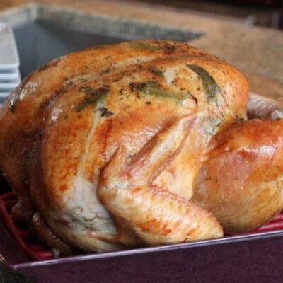 roast turkey with sage leaves in a roasting pan