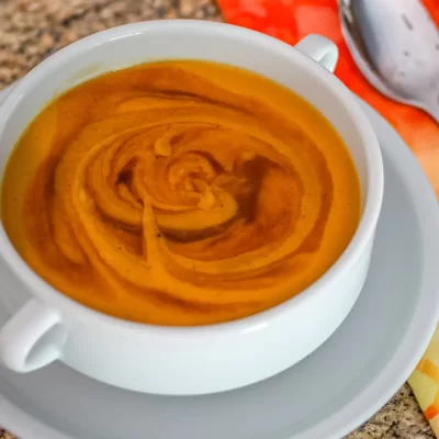 Creamy pumpkin soup with swirls of spice on top.