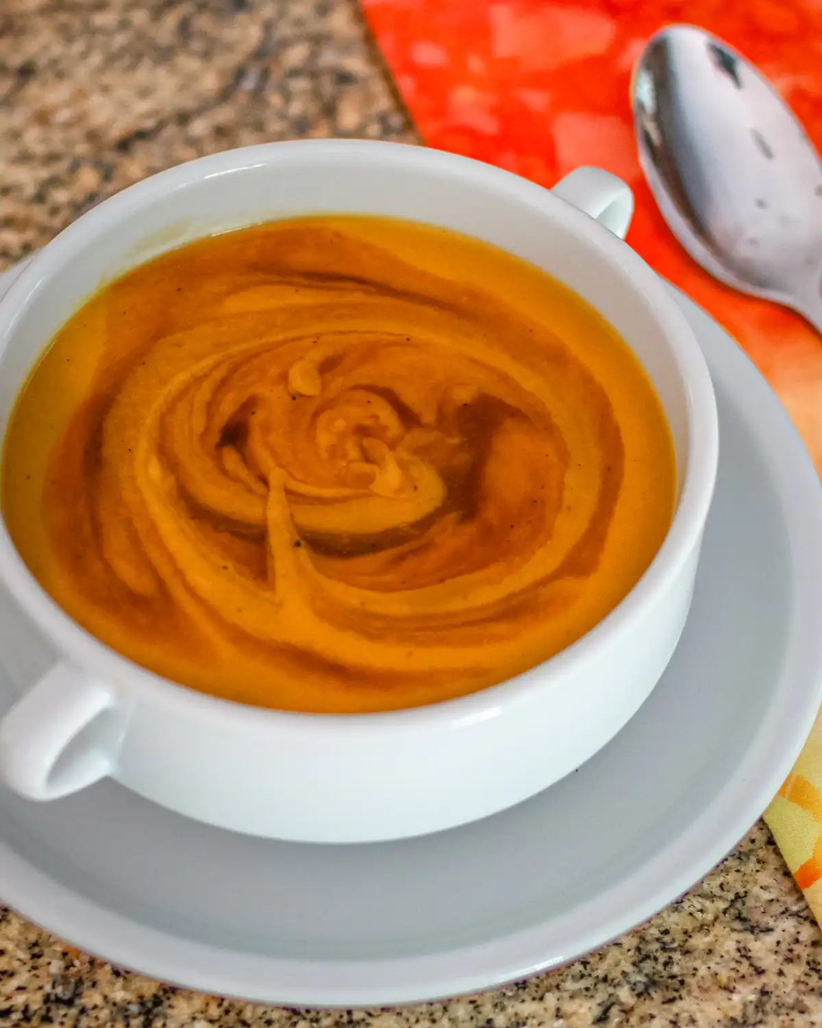 Creamy pumpkin soup with swirls of spice on top.