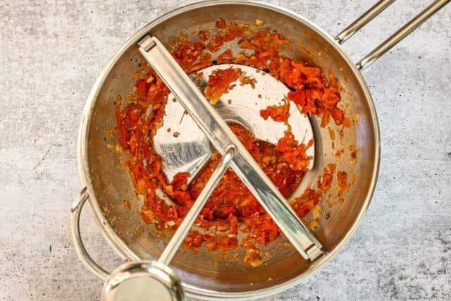 Roasted tomatoes in a food mill.