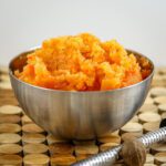 mashed rutabaga and carrots combined in a bowl with a bit of nutmeg