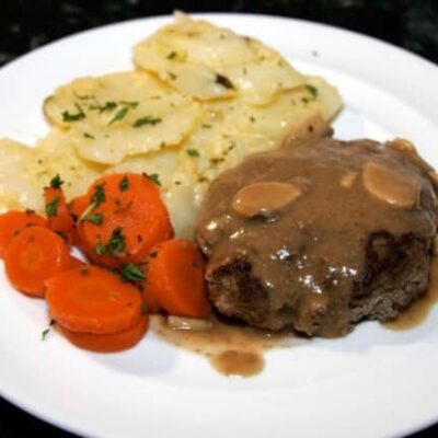 plate of salisbury steak, mushroom gravy, and potatoes