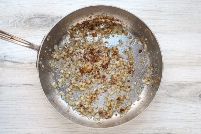 Sautéed onions and garlic in a stainless steel skillet.