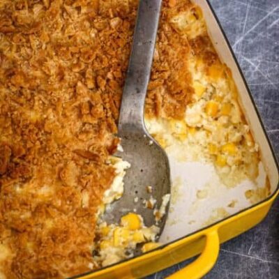 a scalloped corn casserole in a baking dish