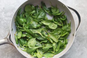 Adding spinach to the skillet