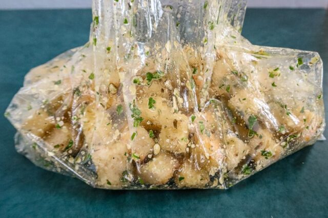 Combining the crouton ingredients in a bag.