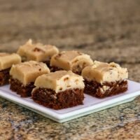 Brownie mix brownies with an indulgent penuche frosting shown on a plate.