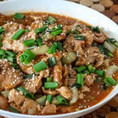 sesame pork with green onions in a bowl
