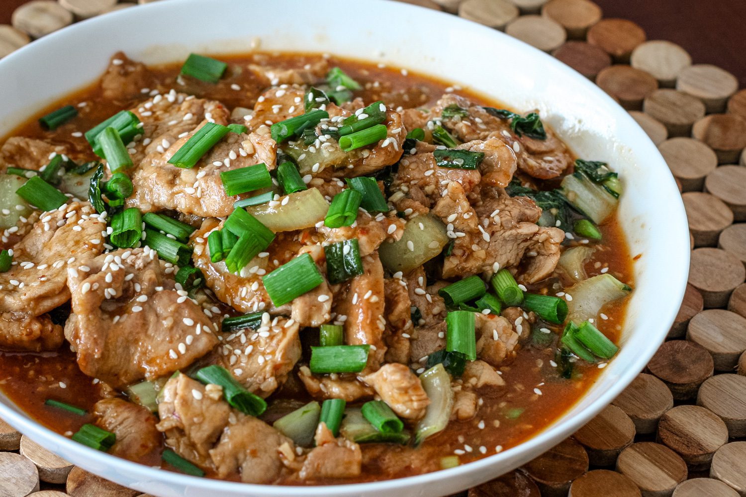 sesame pork with green onions in a bowl