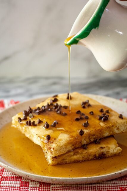 slices of sheet pan pancakes drizzled with syrup