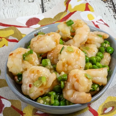 Fried shrimp with chopped green onions on a blue bowl.