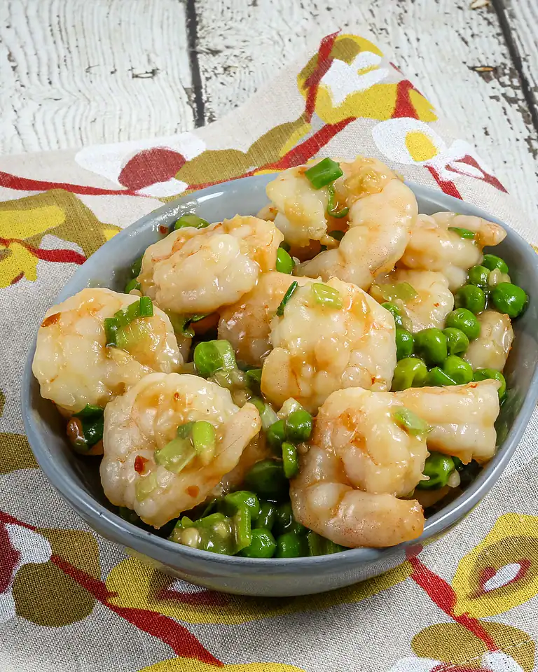 Fried shrimp with chopped green onions on a blue bowl.