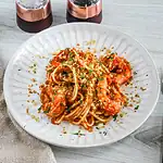 Succulent shrimp and spaghetti garnished with herbs and breadcrumbs.