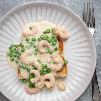 Creamy shrimp and green pea sauce over toasted bread slices.