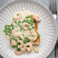 Shrimp wiggle with creamy sauce and peas over toast.
