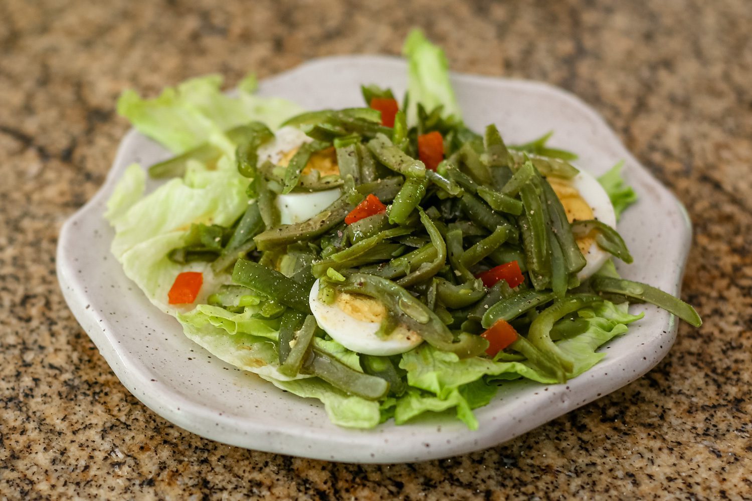 a simple green bean salad on a lettuce-lined plate