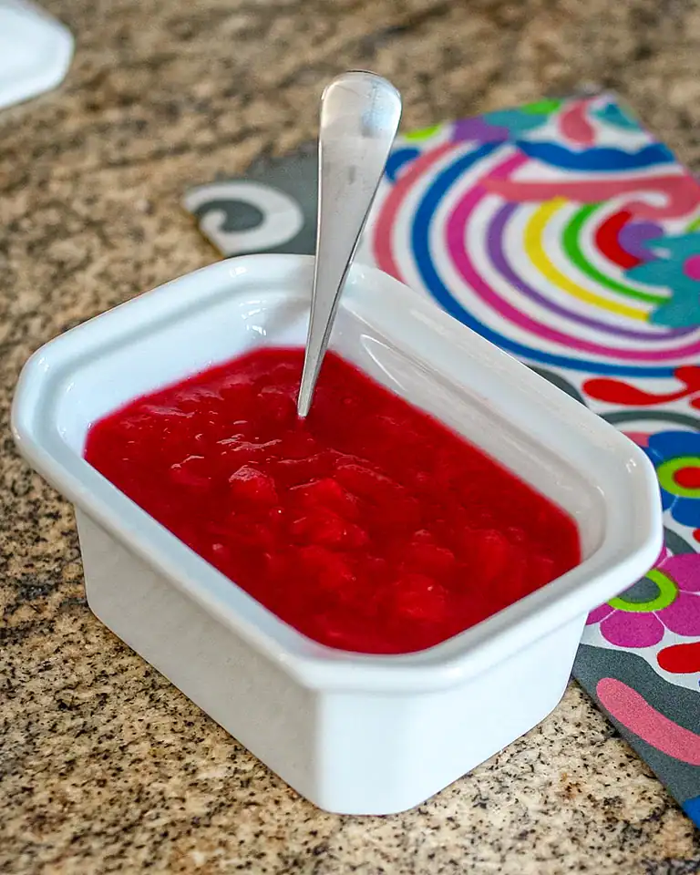 Fresh strawberry jam in a white bowl.