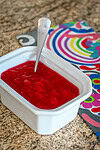 Sweet strawberry jam in a white dish with a spoon.