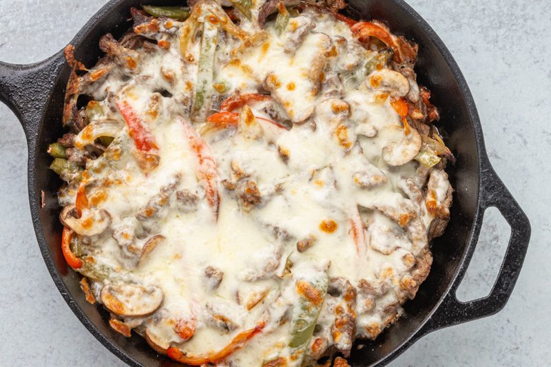 philly cheesesteak skillet in an iron skillet with cheese