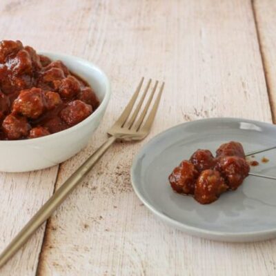 slow cooker barbecue meatballs appetizer in a bowl with a few on a plate