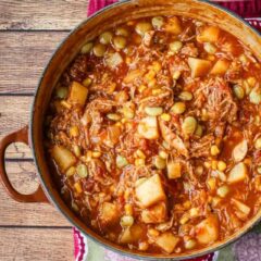 A bowl of rich and delicious Brunswick stew with corn muffins on the side.