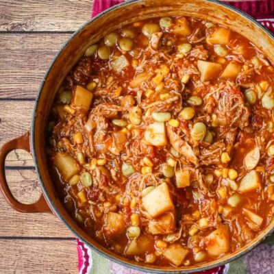 A bowl of rich and delicious Brunswick stew with corn muffins on the side.