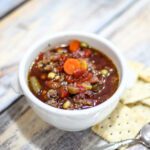 slow cooker hamburger soup in a bowl with crackers.