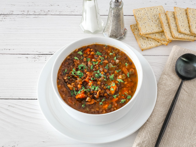 Bowl of lentil soup garnished with parsley