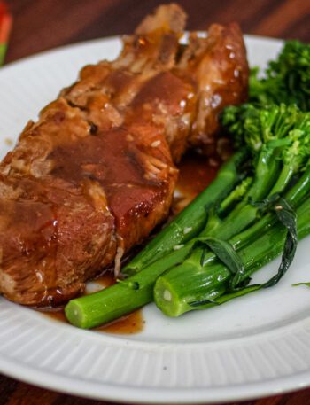 country style ribs with broccolini and barbecue sauce on a plate