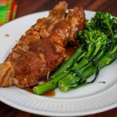 country style ribs with broccolini and barbecue sauce on a plate