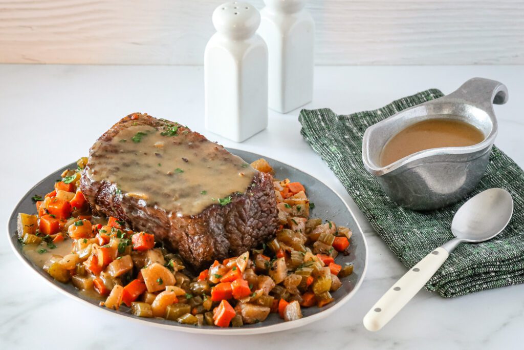 Slow cooker pot roast surrounded with vegetables and gravy